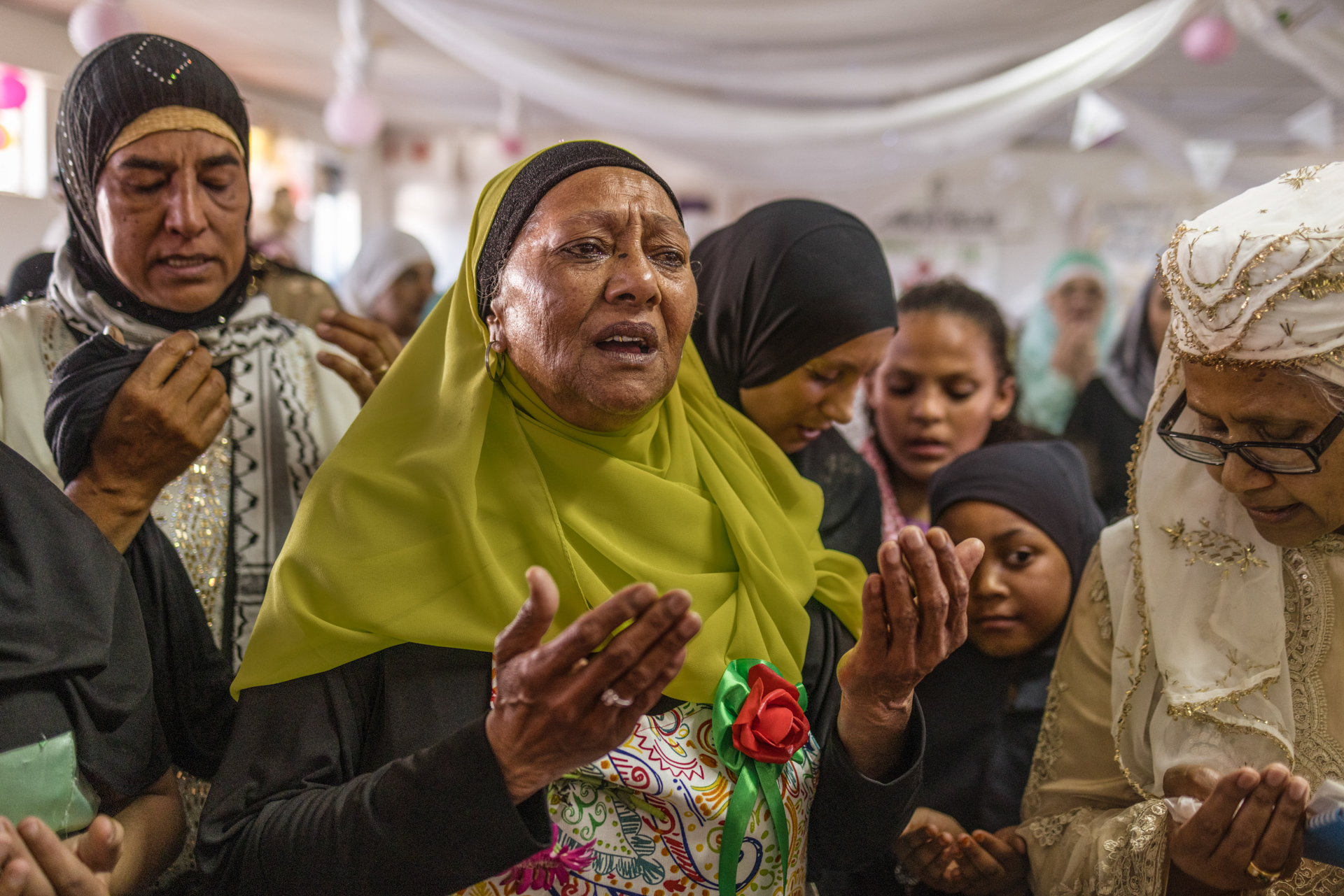 Aunty Rukeya Allow (center) recites the dua (supplication) during the